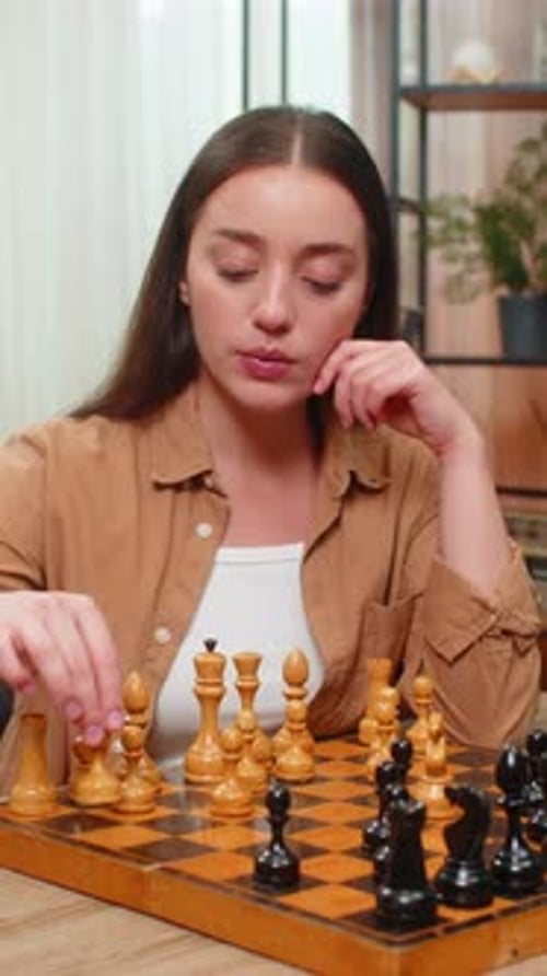 Young Woman Plays Chess Game at Home
