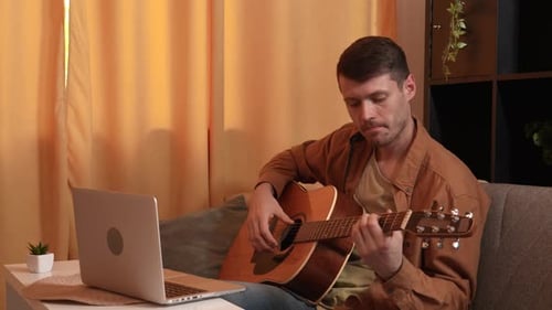 Man Playing Acoustic Guitar at Home