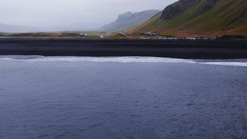 Aerial Black Sand Beach Surf and Volcanic Slopes Near Vik Iceland