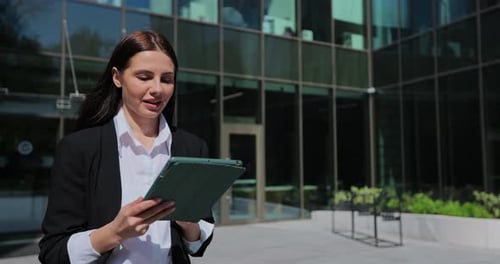 Business Woman Using Touchscreen Pc Tablet Walking Near a Modern Business District Texting and