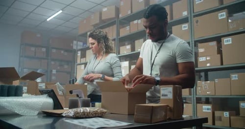 Multiethnische Postangestellte verpacken Kartons und bereiten Pakete für den Versand vor
