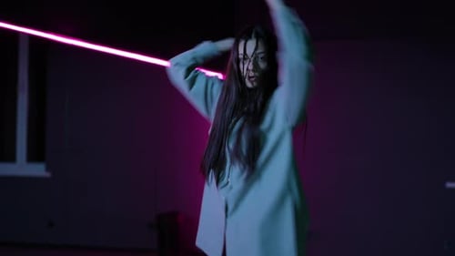 Live Camera A Young Girl Dancing a Modern Dance in a Choreographic Hall with Neon Illuminated