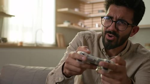 Man Playing Video Game With Controller Enthusiastically Indoors
