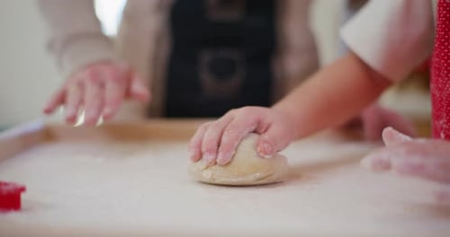 Daddy Teaches Boy How To Knead And Shape Bread Dough In The Kitchen