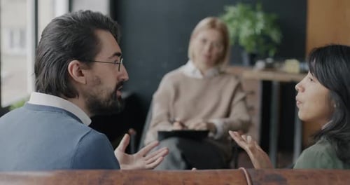 Angry Young People Couple Yelling Fighting During Family Therapy with Psychologist in Modern Office