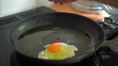 Faire frire les œufs dans une poêle sur une plaque de cuisson avec de l'huile