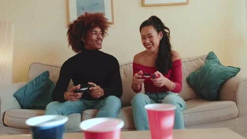 Friends playing video games at home on couch