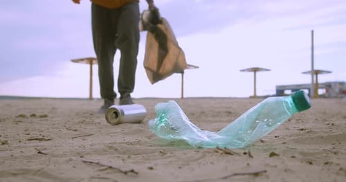 Nettoyer les déchets sur la plage avec un sac en plastique