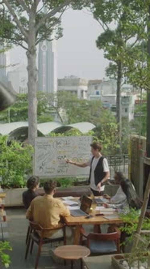 Business Team Listening to Presentation during Meeting on Rooftop Terrace