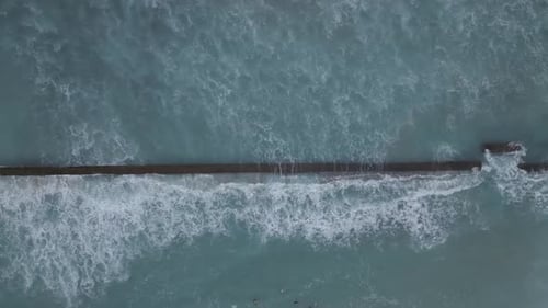 Aerial View of Waves Crashing on Sea Wall