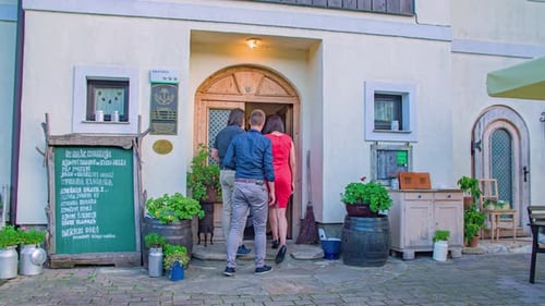 group of friends enter restaurant. Women on fashionable red dress