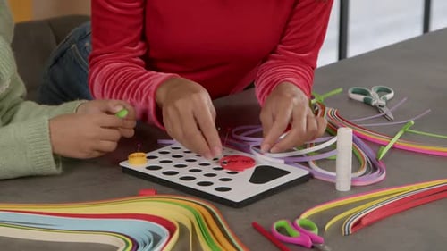 Closeup of Human Hands Making Paper Quilling Designs During Craft Lesson