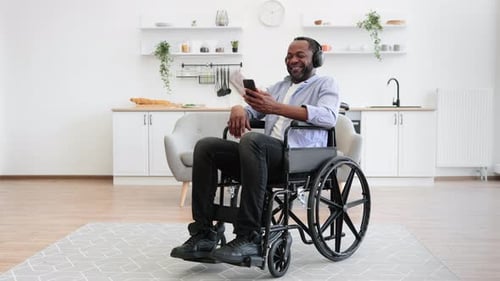 Man in Wheelchair Listening to Music at Home
