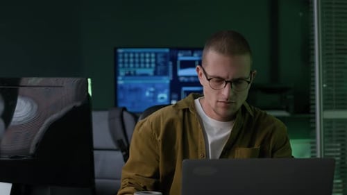 Young Male Programmer Working with Program Coding in Dark Office