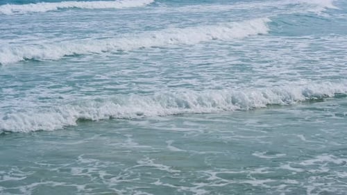 Breathtaking tropical beach with gentle ocean waves under a radiant sun.