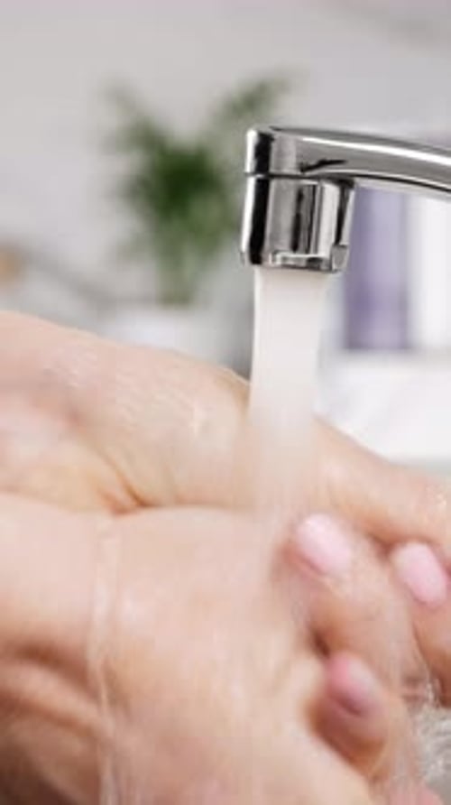 Hand Under Faucet with Running Water Close Up