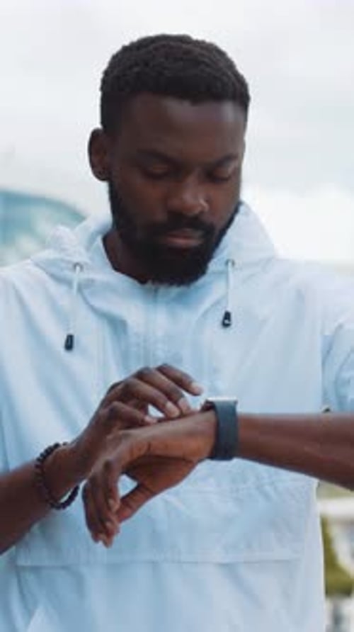 Man Using Smart Watch Outdoors in Urban Setting