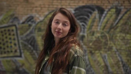Stylish Woman Posing in Front of Graffiti Wall