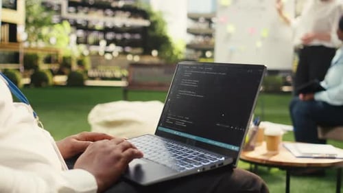 Geschäftsmann, Programmierer, der Binärcode auf einem Laptop bei informeller Arbeit verwendet