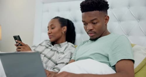 Couple Relaxing in Bed with Technology