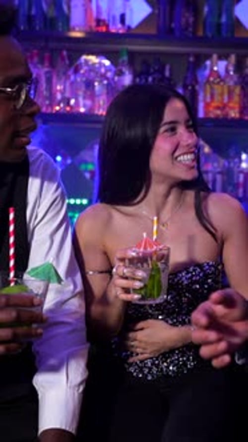 Friends enjoying cocktails and conversation at a lively bar