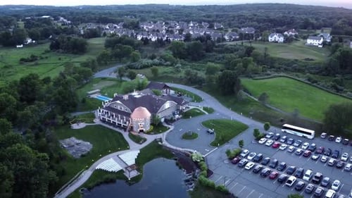 Rotating drone view of a banquet house for celebrations and weddings, surrounded by green land and t