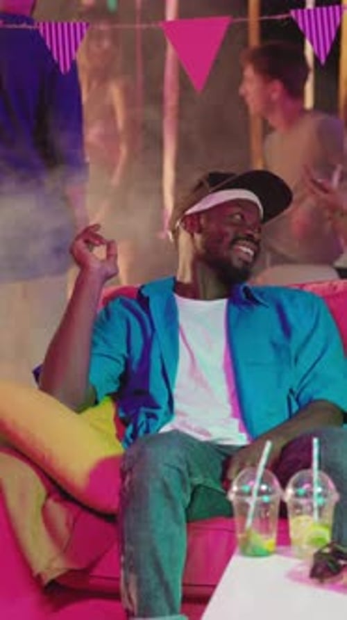 Man Relaxing at a Party on Pink Couch