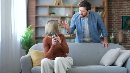 Angry jealous husband suspects his wife of infidelity who uses mobile phone. Quarrel due to jealousy