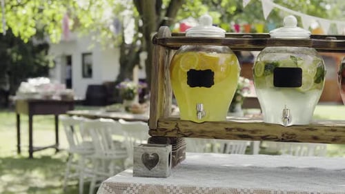 Lemonade jars on a wooden stand in a sunny garden for summer family gathering