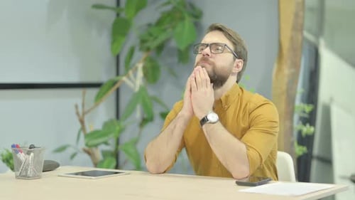 Pensive Young Man Thinking while Sitting in Office
