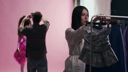 Der Stylist wählt beim Mode-Fotoshooting im Studio ein neues Outfit aus