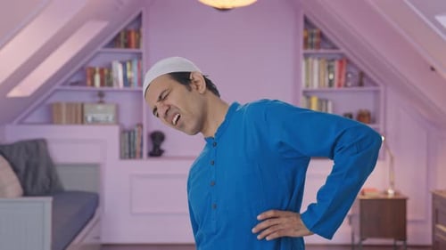 Man Experiencing Lower Back Pain in Bedroom