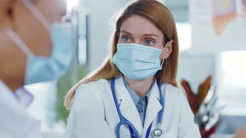 Female doctor consults with colleague in hospital room