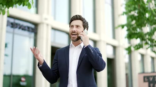 Man in Suit Talking on Smartphone Outside Office Building