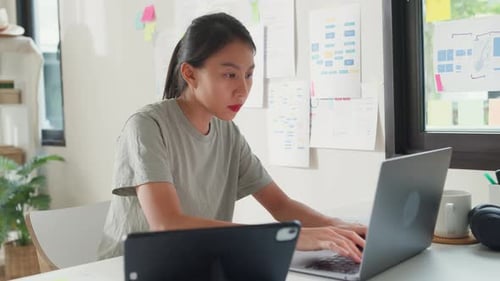 Asia girl IT development programmer typing on keyboard coding programming fixing data code on laptop