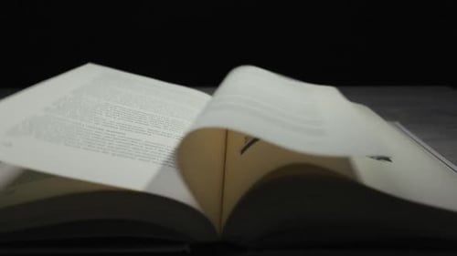 Pages Turning in an Open Book with Text