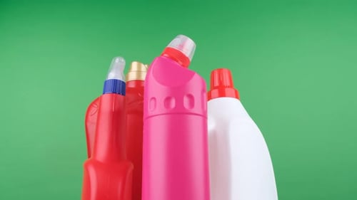 Bottles of Cleaning Products on Green Background