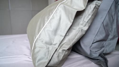 Luxury Pillows on Modern Bed With Satin Sheets