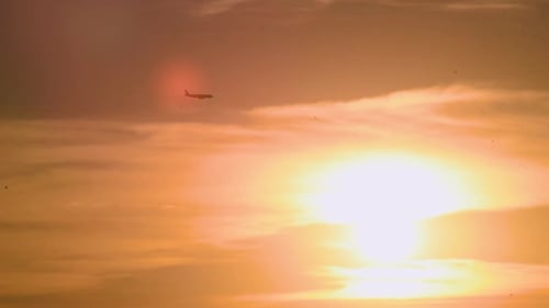 Plane flying over the sunset and clouds preparing for landing