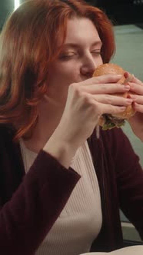 Red Haired Woman Eating Hamburger Close-Up