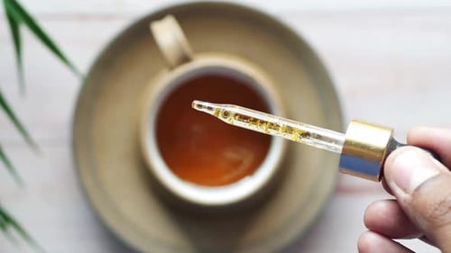 Dropper Over Tea Cup for Health and Wellness