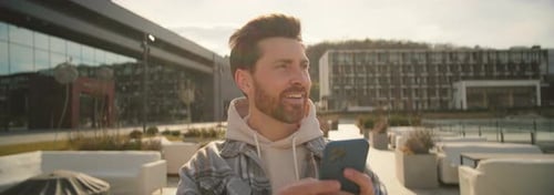 Smiling Man Using Smartphone in an Urban Setting