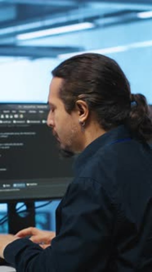 Man Typing Code at Computer in Bright Office