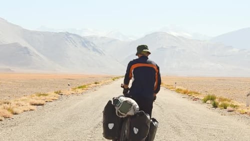 Caucasian Cyclist In Pamir Highway (Back View)