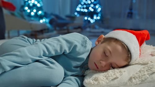 Child Sleeping in Santa Hat on Christmas Eve