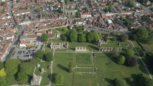 Aerial view of the Glastonbury Abbey ruins an 8th century monastery and gardens. Drone moving upward