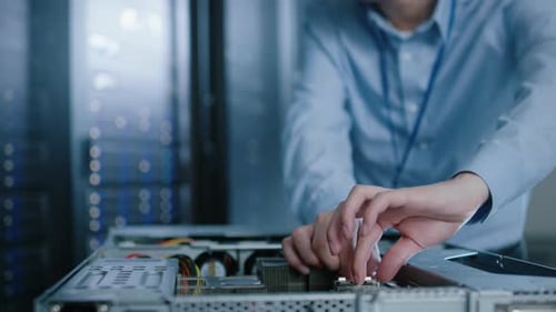 En el centro de datos moderno: un ingeniero de TI que lleva auriculares protectores instala un nuevo hardware para Serv