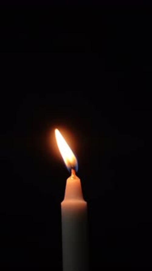 Nahaufnahme einer Kerzenflamme auf schwarzem Hintergrund