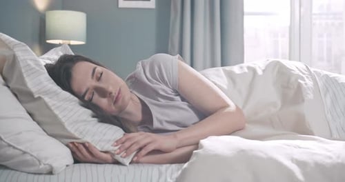 Woman Sleeping Peacefully in Bed in the Morning