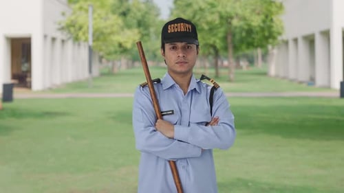 Security Guard With Baton Standing Outside Building